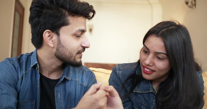 Attractive candid young Indian couple sharing real moments of tender lovely  together at home, holding, touching and feeling each other hands with passion and desire. slow-motion close-up 4k 60fps