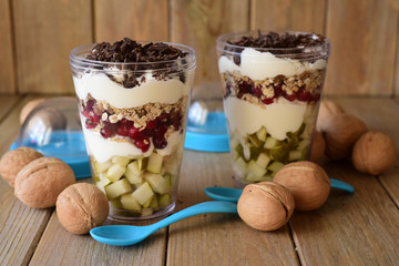 Vegetarian Breakfast in the Bank. Muesli, cranberries, chocolate, pears in a transparent jar on a wooden table.