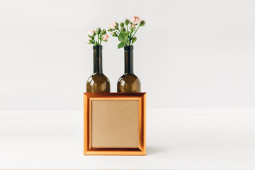 Creative and stylish mockup with green leaves and pink roses.Blank brown notebook.Minimalist flat lay,white wooden background.