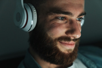Close up of a smiling bearded man wearing earphones