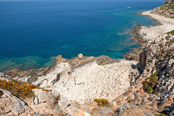 Fototapeta na wymiar Some bathers along the rocky coast of the island of Levanzo in Sicily, Italy.