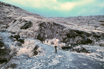 An Infrared look at the landscape of Iceland, a woman is making pictures