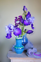 Still life with a beautiful bouquet of irises in a vase on the table