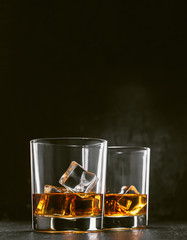 two glasses of alcoholic drink on a dark background