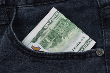 One hundred dollar banknote money in pocket jeans pants background texture. 100 dollar bill close up