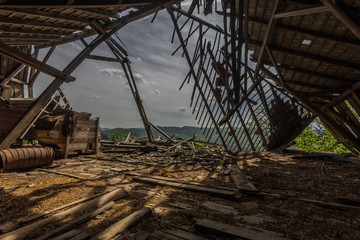 eingebrochener dachstuhl von einem bauernhof mit landschaft