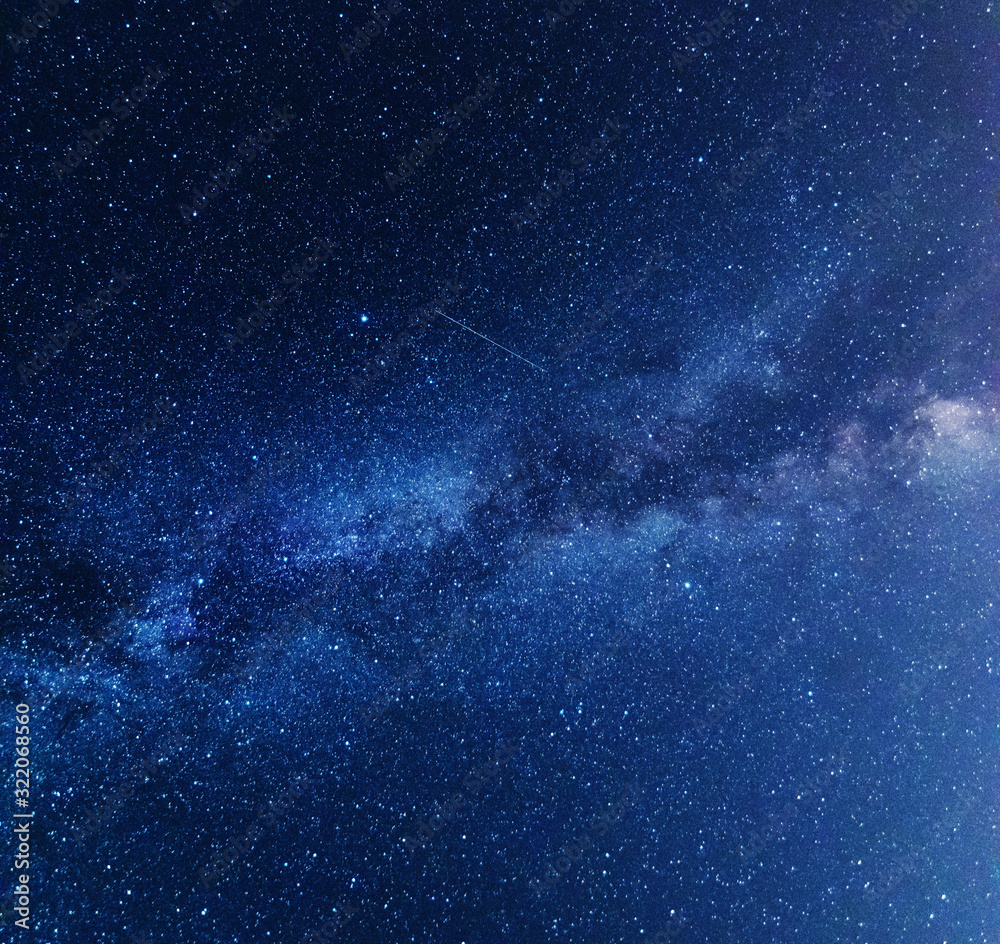 Wall mural a night on the lake with a bright milky way in the sky and millions of stars glittering in the water