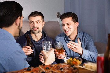 Friendly meeting in men company over beer with pizza