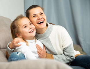Happy family woman  with small daughter laughing at home