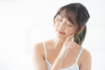 Fototapeta premium Portrait of beautiful young asian woman smile while wake up healthy and wellness with sunrise at morning in the bedroom, asia girl skin care with happy with fresh, lifestyle and relax concept.