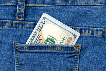 One hundred dollar banknote money in pocket jeans pants background texture. 100 dollar bill close up