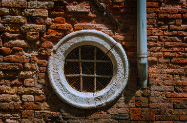 Venice Italy. Old circular vintage window in an old brick wall