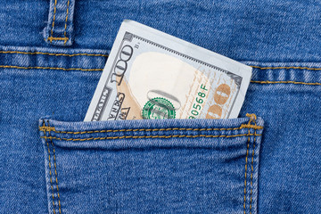 One hundred dollar banknote money in pocket jeans pants background texture. 100 dollar bill close up