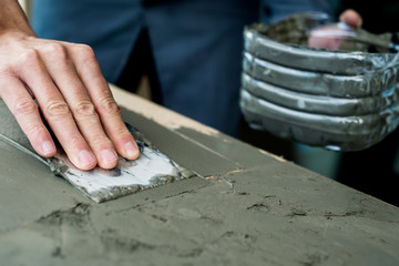 man spreading some concrete on a surface