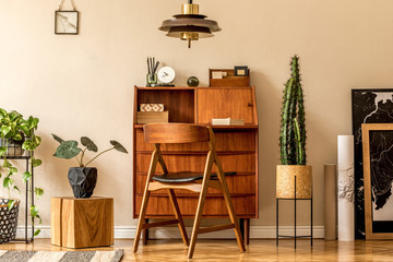 Retro interior design of living room with wooden vintage bureau, design chair, plants, cacti, maps,...