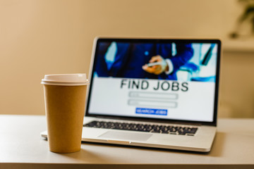 Laptop with cup of coffee on a table.