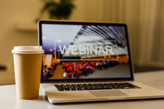 Close-up Of Businesswoman Video Conferencing On Laptop With Disposable Cup