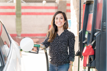 Smiling Customer Fueling Her Car At Gas Station