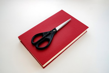 on the red book, there are black scissors on top