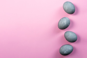 Four easter eggs in color of concrete on pink background. Top view, flat lay. Copy space. Happy Easter concept. Easter greeting card.