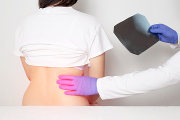An orthopedic doctor examines a patient using an x-ray for a fracture of the back ribs. Concept of...