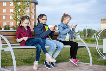 Children and gadgets in the city park.