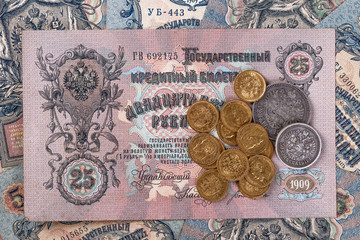 Gold and silver coins of the Russian Empire19 - 20 century in the background kopyur.Five rubles Nicholas II.Concept Russian antiques.Saint George cross of Imperial Russia.Antikvariat.