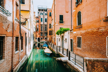 Fototapeta na wymiar Venice Italy. Canal with old typical orange facade houses, patio and windows