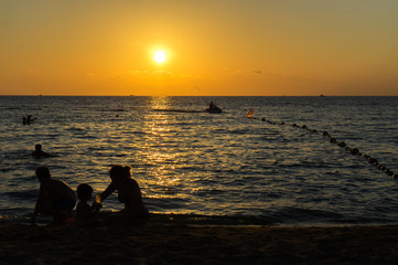 Naklejka na ściany i meble Beautiful sunset on the beach with people silhouttes on the Phu Quoc island.