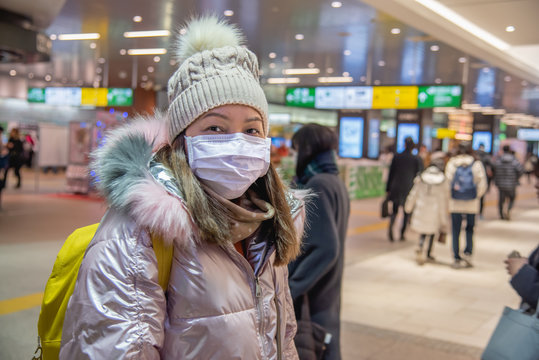 Traveler Woman Wears Medical Mask To Protect Against Coronavirus On Public Transport Station.