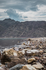 rocky shore of a reservoir with clear blue water high in the mountains