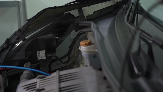 Checking the car hood open at service station with flashlight internal parts engine inside of the machine vehicle motor repair camera movement