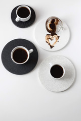Round coasters made of artificial stone tabletop on a white background. Food stand. Three coffee mugs top view. Fortune telling.