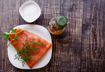 a piece of fresh salmon with a bottle of olive oil and sea salt