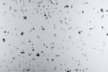 Silver falling confetti on metallic backdrop. Festive and party concept.