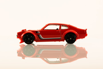 Toy muscle car on white with reflection