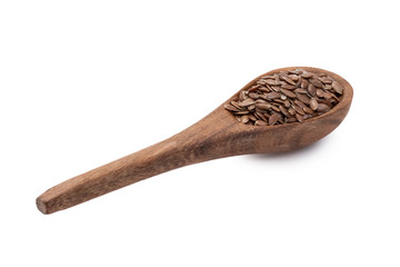 Linseeds or flax seed on a brown wooden spoon seen obliquely from the handle and above and isolated on white background
