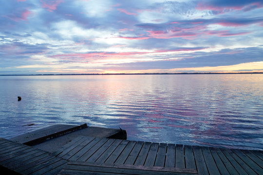Biscarrosse lake at sunset with wooden boat pontoon jetty in france