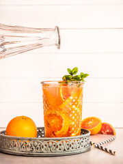 Wasser läuft in ein Glas mit frischen Blutorangen Scheiben, Sommer, Getränk 