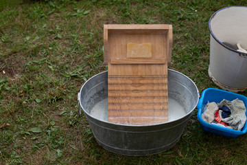 Old zinc wash tub with wooden washboard for getting the clothes clean - 322080532