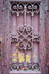 Old entrance doors of buildings with metal bars. Background for old architecture. The craftsmanship of a blacksmith.