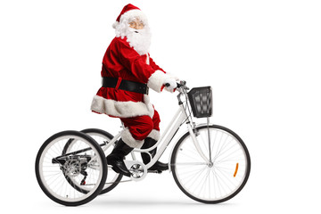 Santa Claus riding a white tricycle and looking at the camera