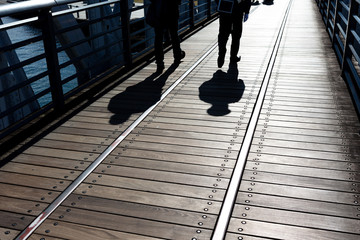 神奈川県横浜市みなとみらい、線路跡が残る新港橋を渡る人のシルエット・日本