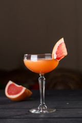 Orange margarita alcohol cocktail with grapefruit on black table