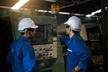 Two industrial workers operate lathes in the metalworking machinery industry. Industrial people meeting together in factory.