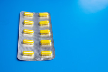 pack of yellow capsules on a blue background