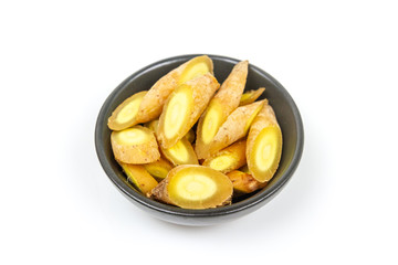 Finger root (Krachai) Sliced on black ceramic bowl on wooden background, finger root is herb and Thai food ingredient.