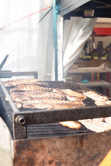 Several racks of pork spare ribs cooked on fire barbecue grill - 322083791