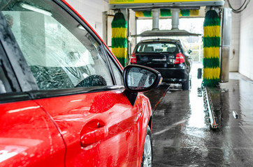 Red car at an automatic car wash.