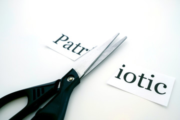 scissors cut a sheet of paper that says Patriotic